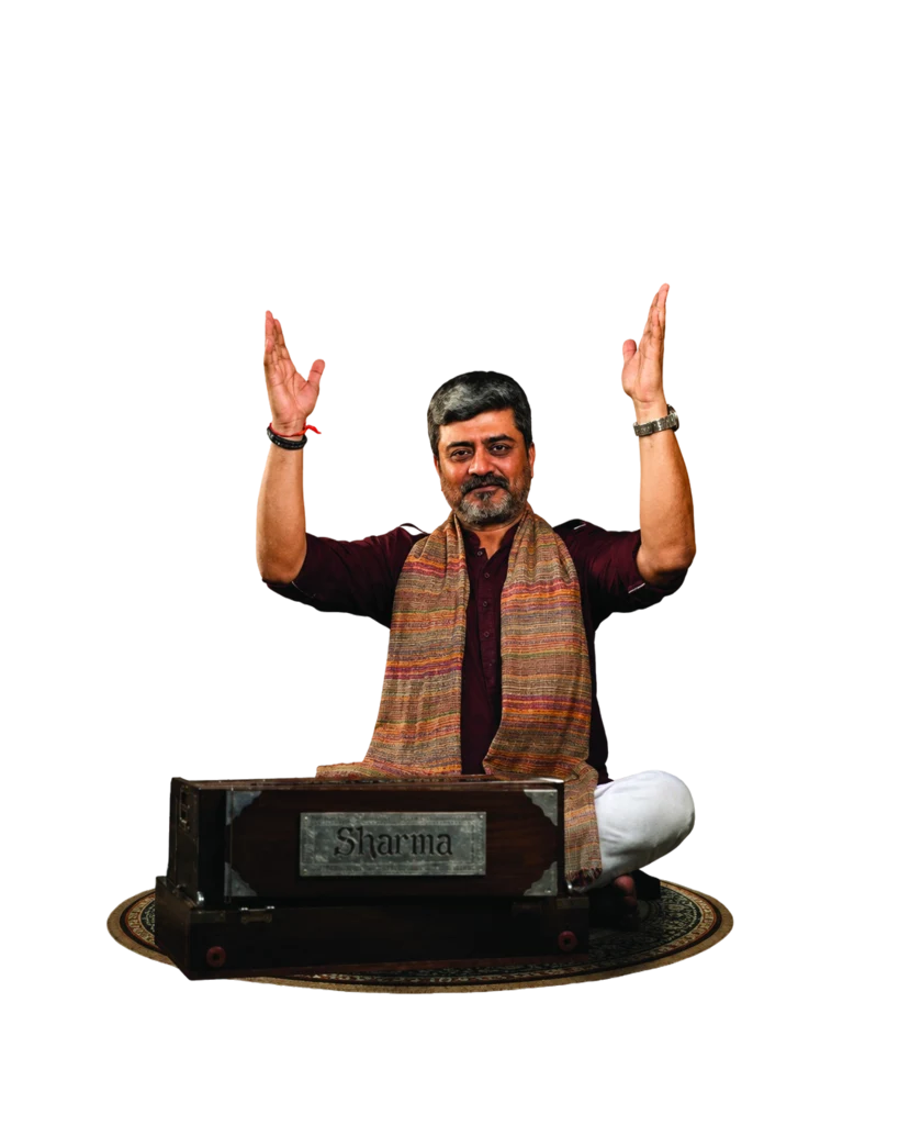 Dr. Ranjit Vank seated with a harmonium